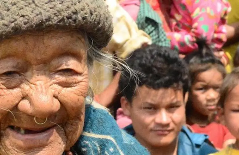 An elder and children of the community gathered together